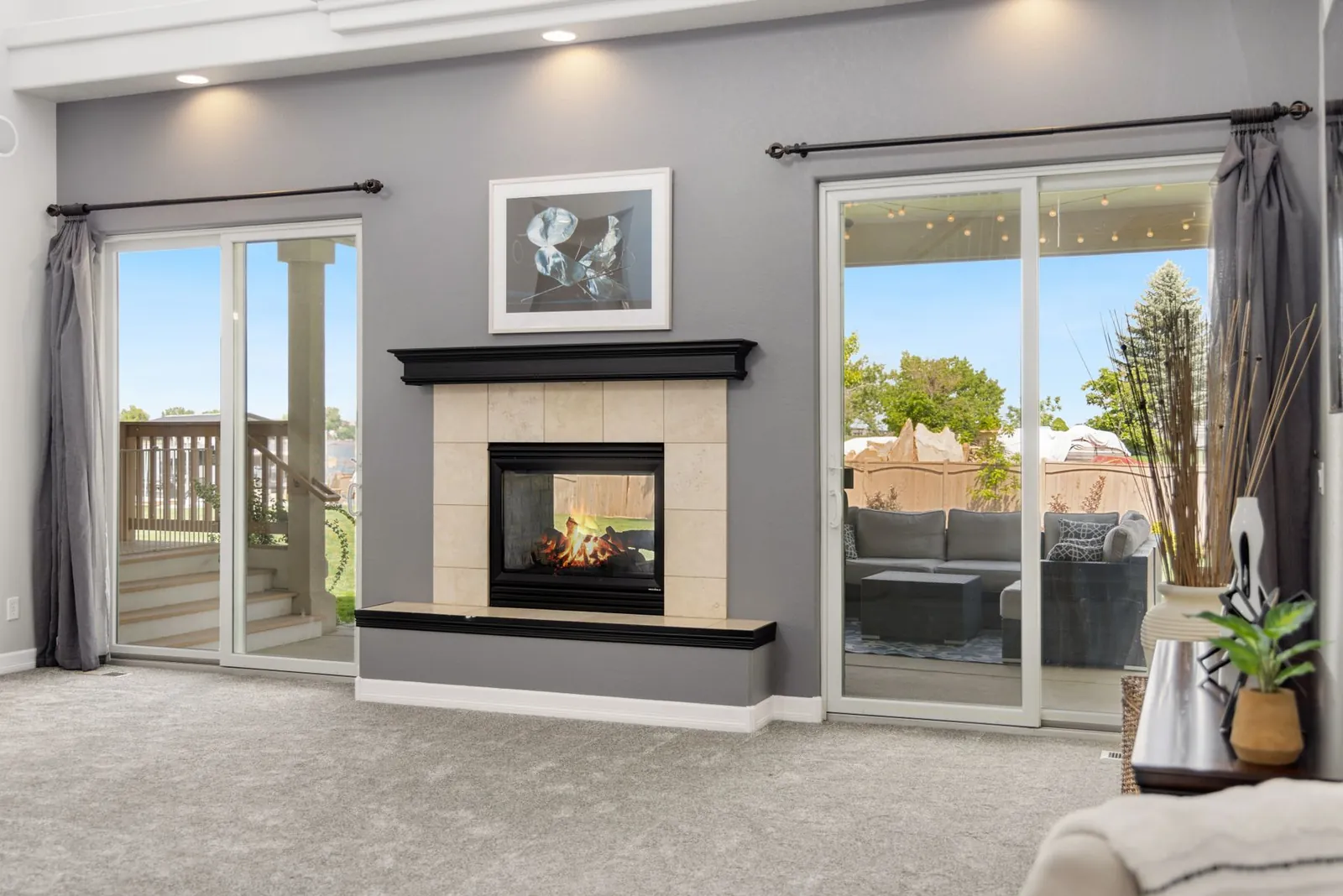 Modern living room with a tiled gas fireplace between two sliding doors